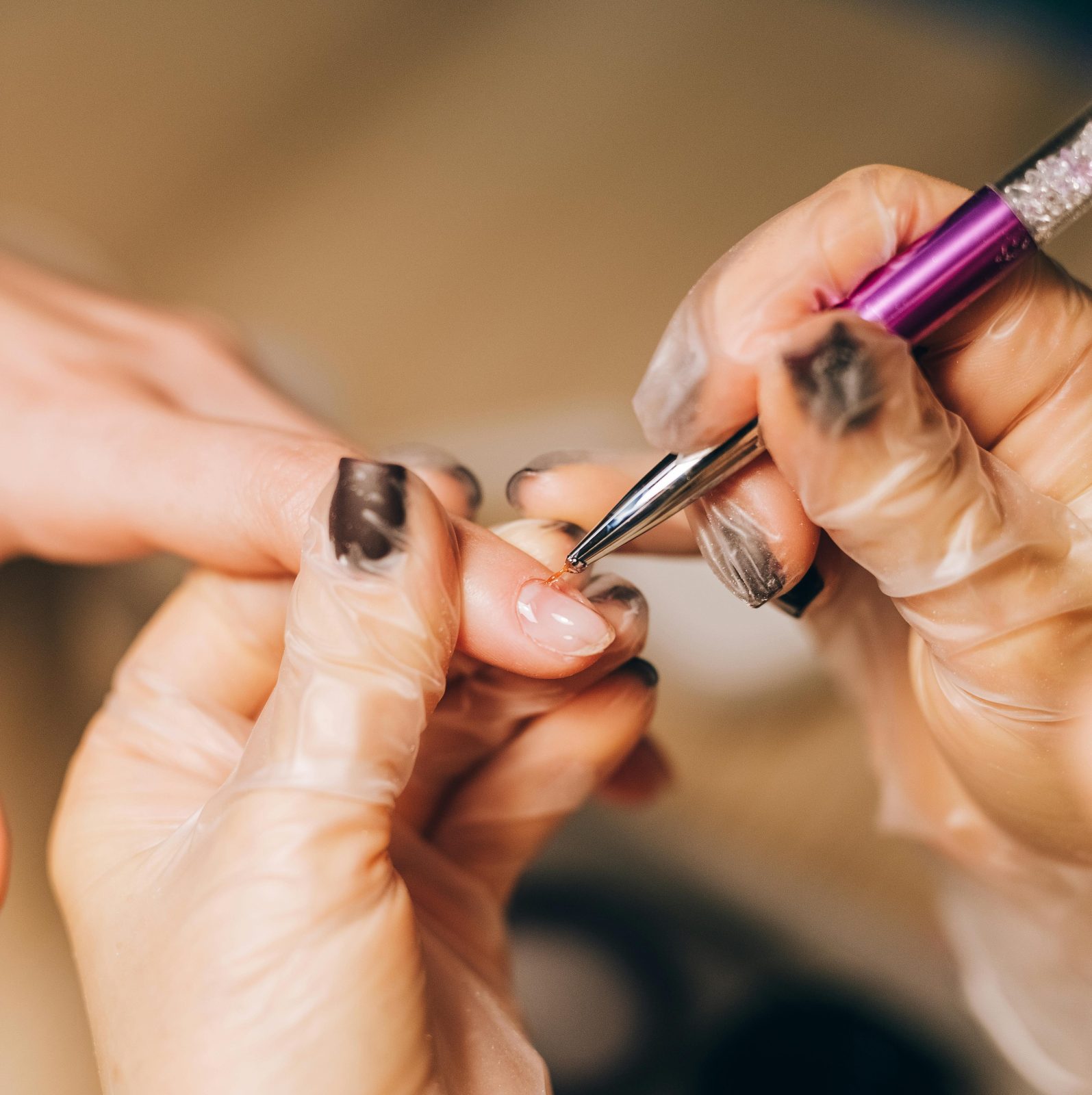 woman painting nails with fine nail art brush